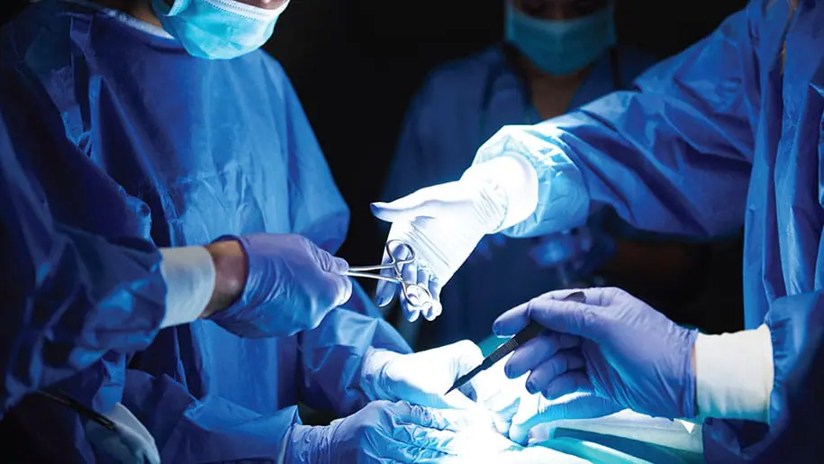 sets of hands wearing surgical gloves during an operation